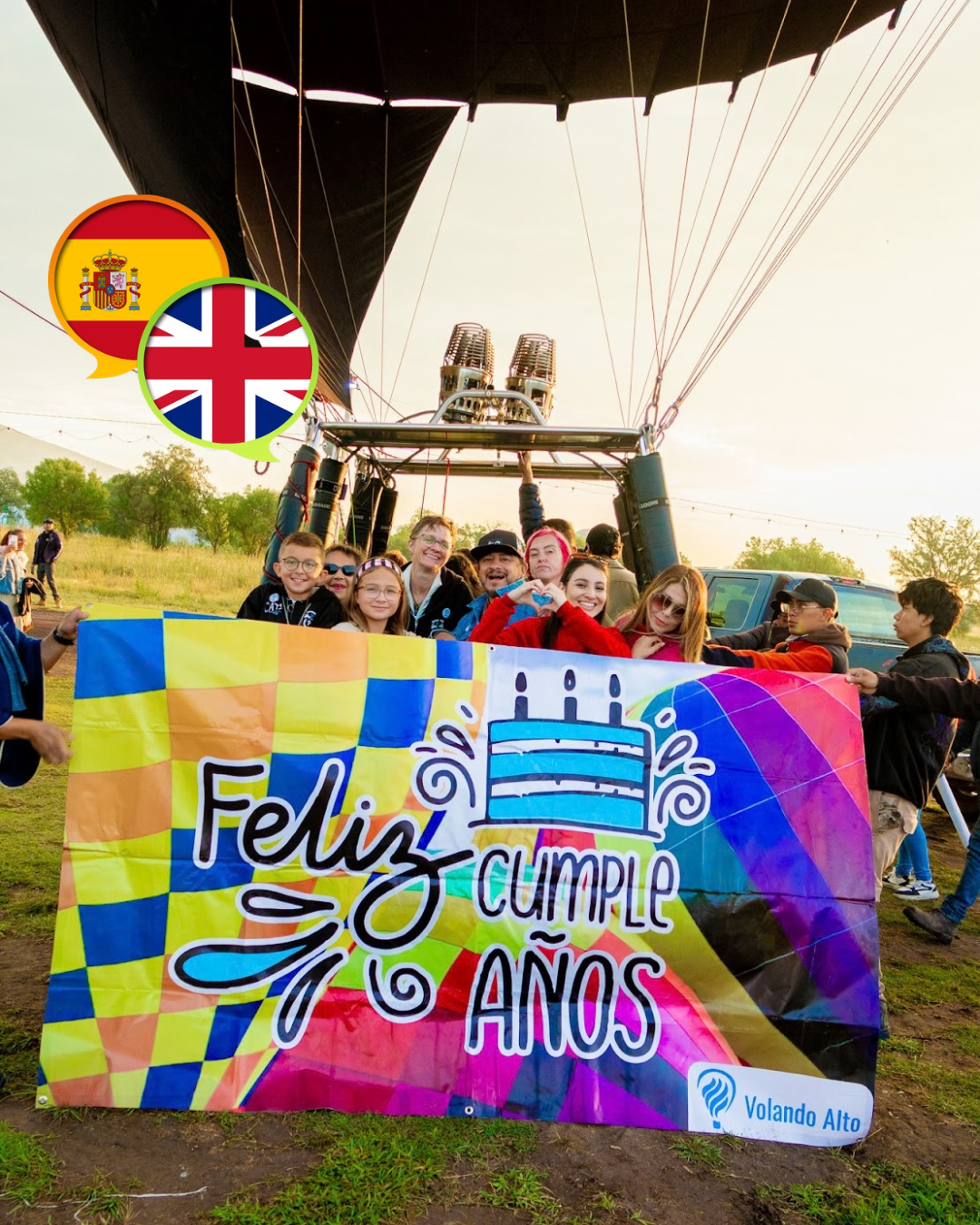 Grupo de viajeros sosteniendo una lona de feliz cumpleaños frente a un globo aerostático
